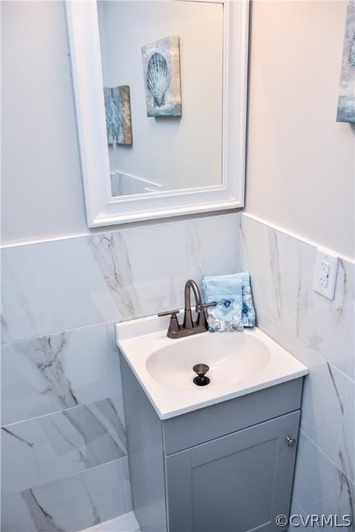 bathroom with vanity and tile walls