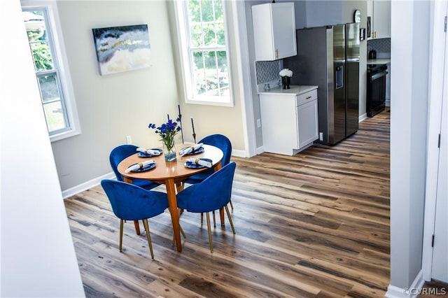 dining space featuring dark wood-type flooring and a wealth of natural light