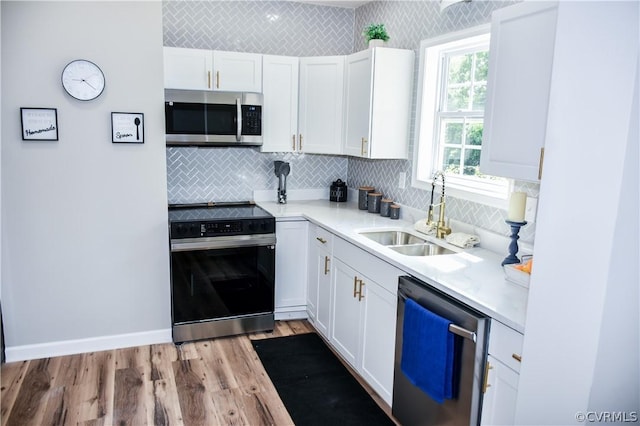 kitchen featuring white cabinets, light hardwood / wood-style floors, sink, and stainless steel appliances