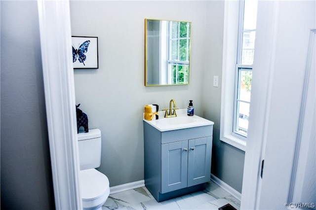 bathroom featuring vanity, toilet, and a healthy amount of sunlight