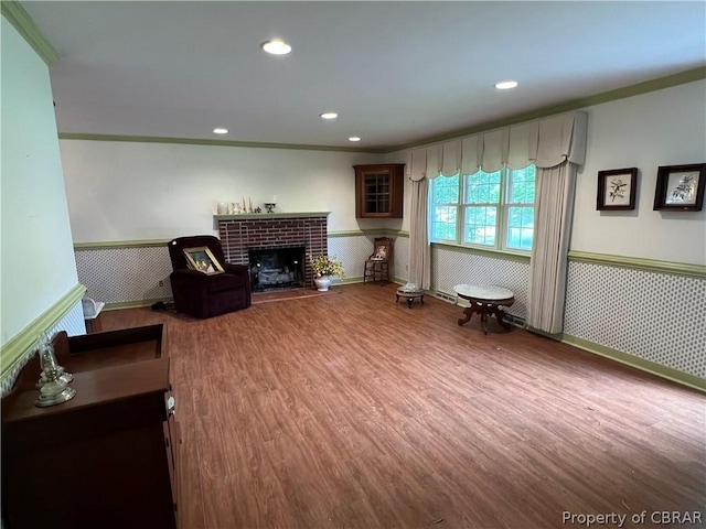 living room with ornamental molding, hardwood / wood-style floors, and a fireplace