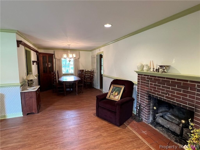 living room with ornamental molding, dark wood-type flooring, an inviting chandelier, and a fireplace