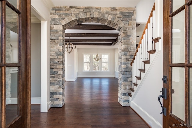 entryway featuring beamed ceiling, dark hardwood / wood-style flooring, and a chandelier