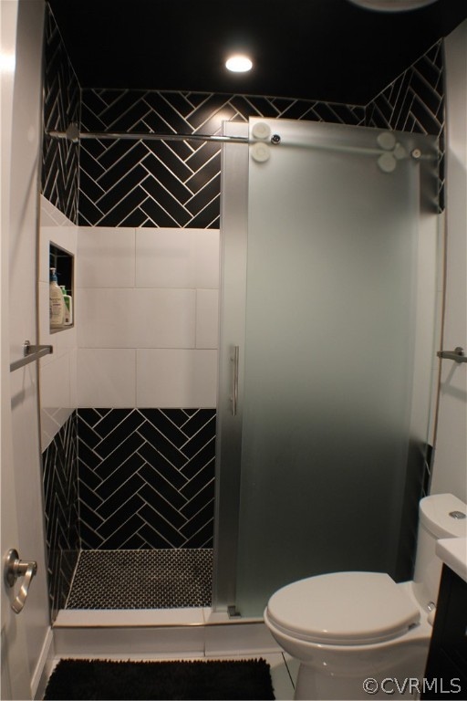 bathroom with toilet, vanity, tile patterned floors, and walk in shower