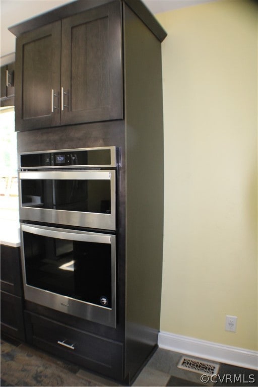 room details featuring dark brown cabinets and double oven