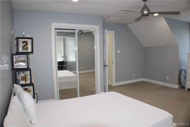 carpeted bedroom with a closet, vaulted ceiling, and ceiling fan