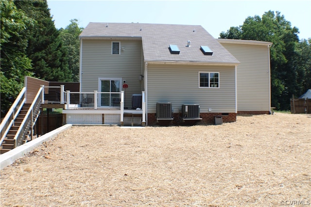 rear view of house with cooling unit and a deck