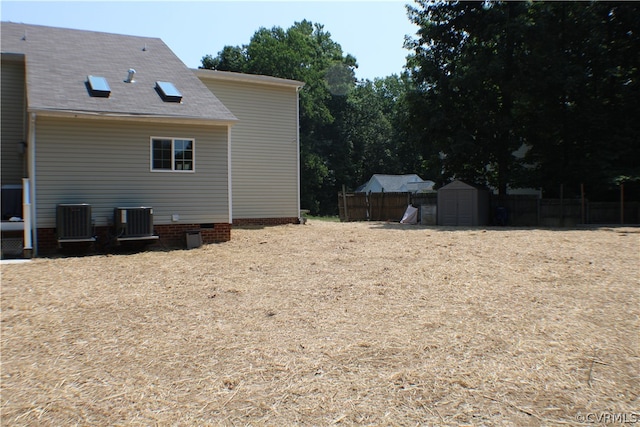 view of property exterior with central AC unit and a storage shed