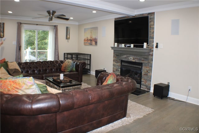 living room with a stone fireplace, ceiling fan, hardwood / wood-style flooring, and ornamental molding