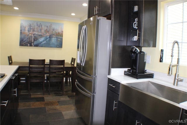 kitchen with dark brown cabinets, sink, crown molding, and stainless steel fridge with ice dispenser