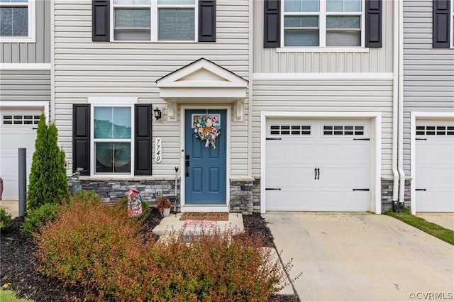 7740 Baron Berkley Ln, New Kent, VA 23124 - doorway to property featuring stone siding, an attached garage, driveway, and board and batten siding