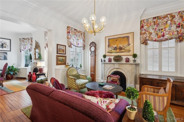 living area with hardwood / wood-style floors, an inviting chandelier, and ornamental molding