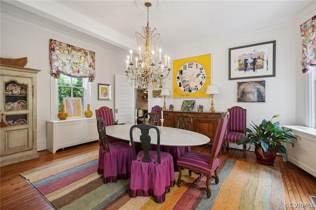 dining space with hardwood / wood-style floors, a notable chandelier, and ornamental molding