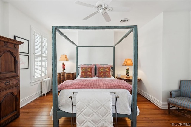 bedroom with hardwood / wood-style flooring, ceiling fan, and radiator