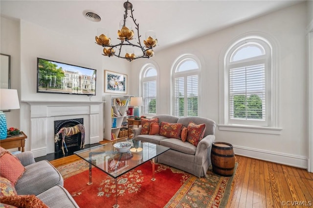 living room featuring wood-type flooring and an inviting chandelier