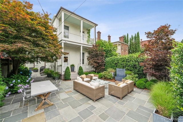 view of patio with an outdoor living space and a balcony