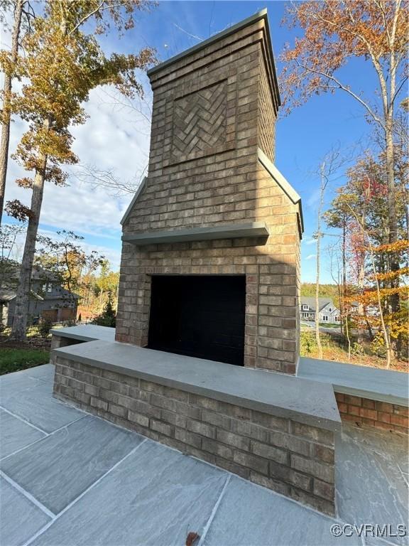 exterior details featuring an outdoor brick fireplace