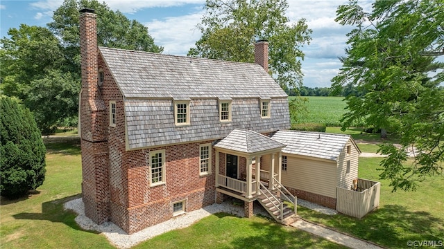 rear view of house featuring a yard