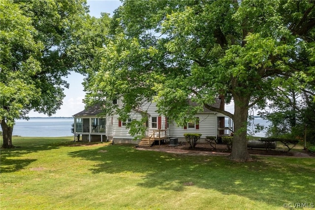 rear view of house featuring a yard, a water view, and central AC