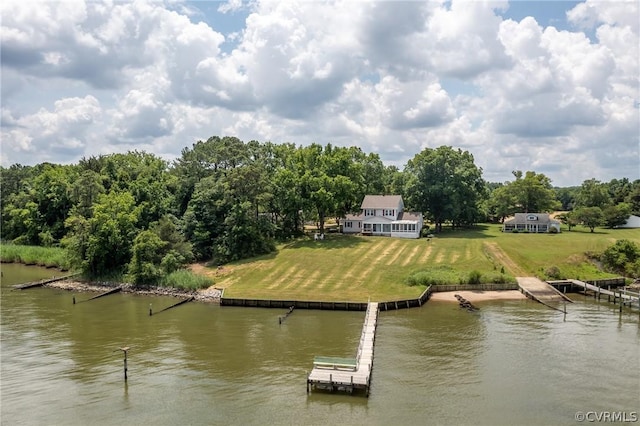 view of dock with a lawn and a water view