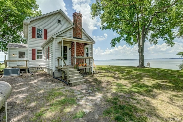 view of front of property with a water view and a chimney