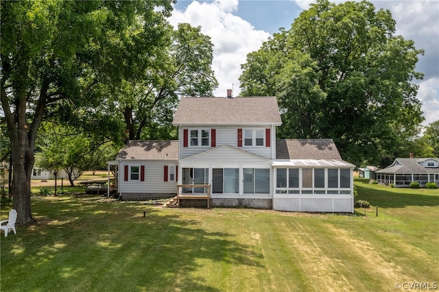 colonial-style house with a sunroom and a front lawn