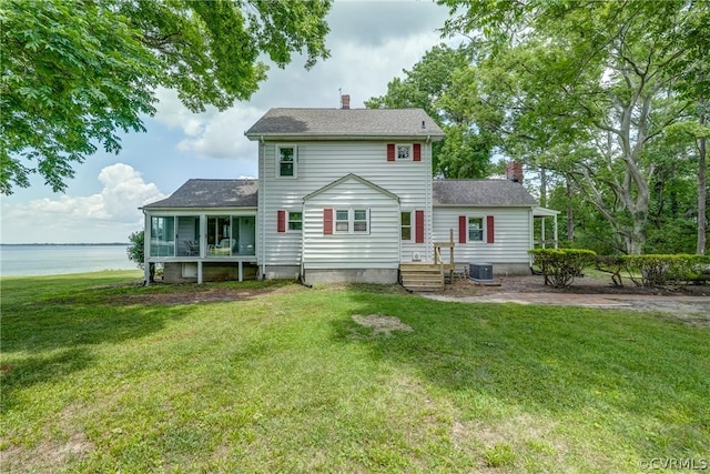 back of house with central AC and a yard