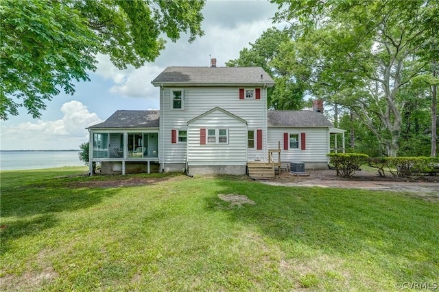 back of property featuring a water view, central AC, a yard, a sunroom, and a chimney