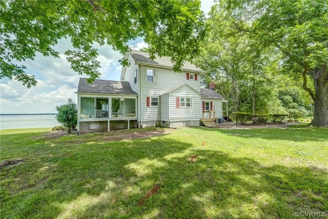 back of property featuring a lawn, entry steps, and a water view