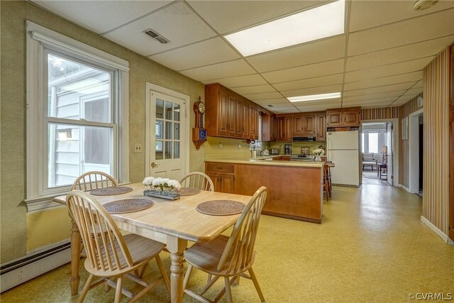 dining area featuring a baseboard radiator and a paneled ceiling