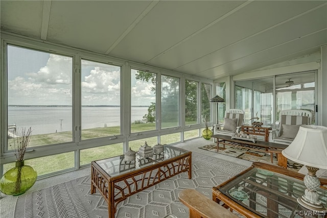 sunroom / solarium featuring ceiling fan and a water view