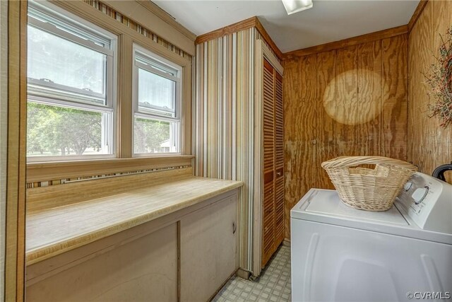 clothes washing area featuring independent washer and dryer, wooden walls, and light tile flooring