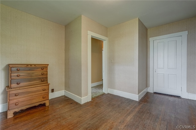 unfurnished bedroom with dark hardwood / wood-style floors and a closet