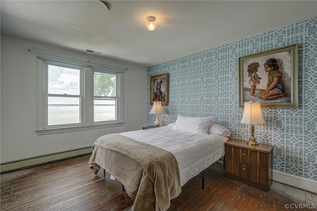 bedroom featuring visible vents, baseboards, wallpapered walls, dark wood finished floors, and baseboard heating