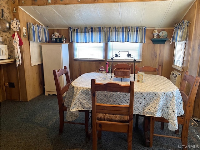 dining area featuring a wealth of natural light, wood walls, and carpet floors