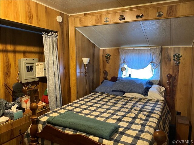 bedroom featuring wooden walls and lofted ceiling