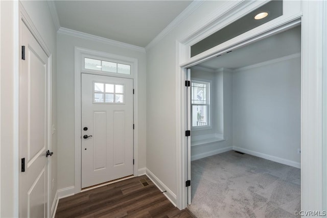 foyer entrance featuring crown molding and dark carpet