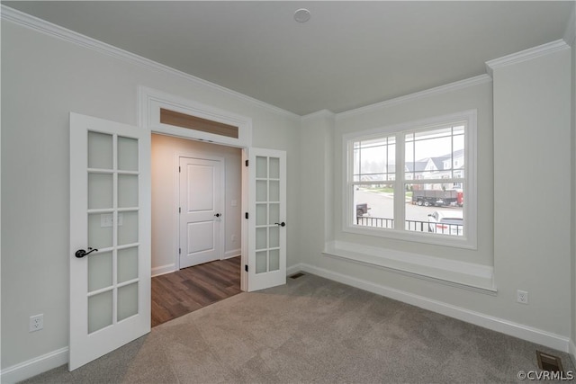 carpeted empty room featuring ornamental molding and french doors