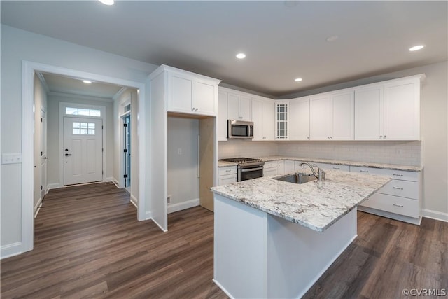 kitchen with a center island with sink, stainless steel appliances, light stone counters, white cabinets, and sink