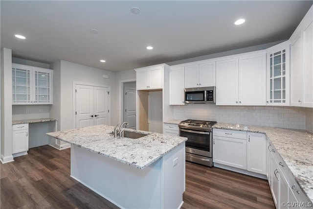 kitchen featuring appliances with stainless steel finishes, white cabinetry, a center island with sink, and sink