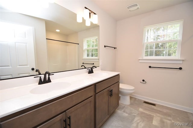 bathroom with vanity, toilet, and a shower