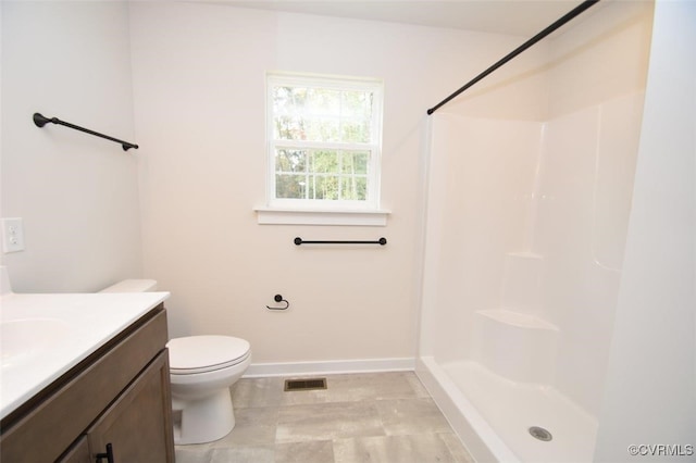 bathroom featuring vanity, toilet, and walk in shower