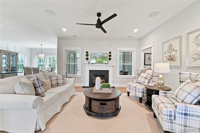 living room with light wood-type flooring and ceiling fan