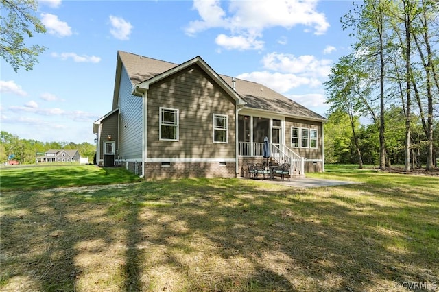 rear view of property with a lawn, a sunroom, and a patio