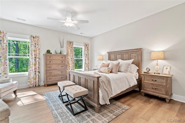 bedroom with multiple windows, ceiling fan, and light wood-type flooring