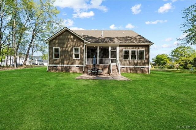 rear view of property with a yard, a patio, and a sunroom