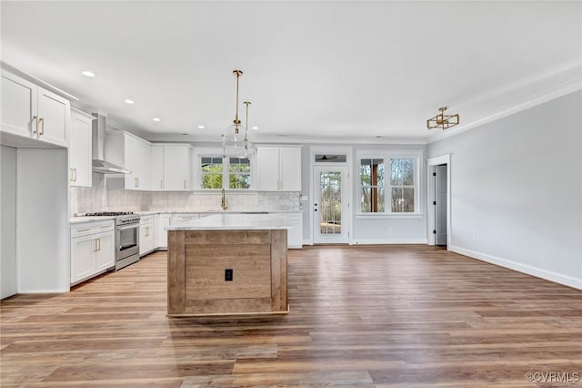 kitchen featuring high end range, light hardwood / wood-style floors, and wall chimney range hood