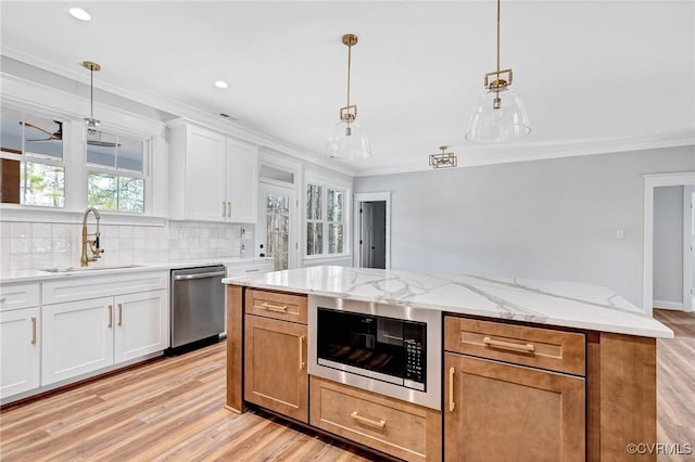 kitchen with sink, white cabinetry, stainless steel appliances, and a wealth of natural light