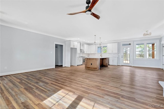 unfurnished living room with ceiling fan, light wood-type flooring, and crown molding