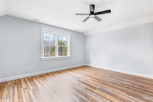 empty room with ceiling fan, hardwood / wood-style floors, and lofted ceiling